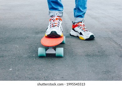 Young Guy In Ripped Jeans Standing With Penny Board In The Park. Summer Activities Skateboarding