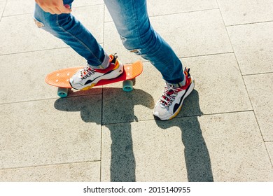 Young Guy In Ripped Jeans Standing With Penny Board In The Park. Summer Activities Skateboarding