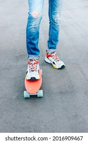 Young Guy In Ripped Jeans Standing With Penny Board In The Park. Summer Activities Skateboarding