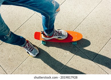 Young Guy In Ripped Jeans Standing With Penny Board In The Park. Summer Activities Skateboarding