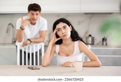 Young guy screams during family quarrel with young woman in kitchen - Powered by Shutterstock