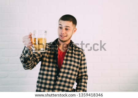 young guy in a shirt with a glass of beer in his hand