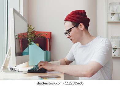 Young guy sitting and working at the computer