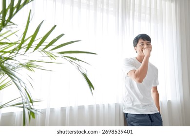 Young guy standing at the front of window with bright sunlight. 170