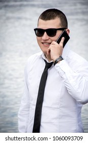 Young guy wearing tie using smartphone. Positive and cheerful portrait