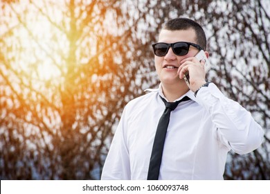 Young guy wearing tie using smartphone. Positive and cheerful portrait