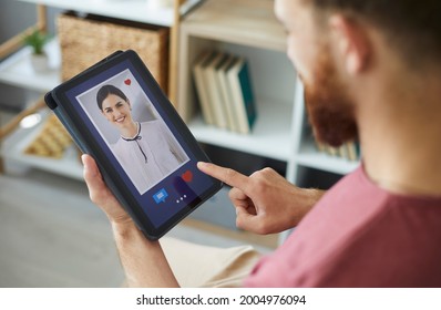 Young Guy Who Wants To Find Love Online Looking At Digital Tablet Display, Sending Messages And Liking Profile Pics Of Beautiful Women On Modern Dating Website Or Mobile App. Close Up, Closeup Shot