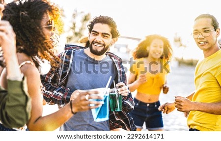 Young guys and girls dancing at sunset concert on summer vacation days - Fancy life style concept with friends having genuine fun day together at spring break festival beach party - Warm bright filter
