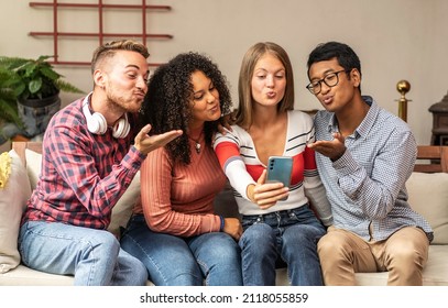 Young guys group sending kisses during a video call with friends - Community concept with multicultural and multiethnic friends having fun video calling on web social platform - Diversity, friendship