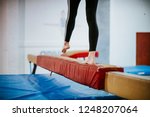Young gymnast balancing on a balance beam