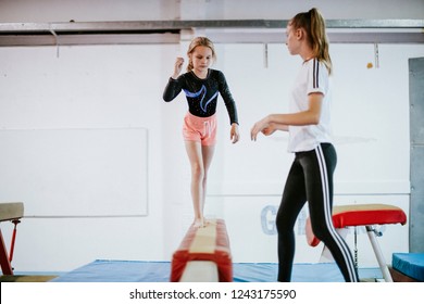 Young gymnast balancing on a balance beam - Powered by Shutterstock