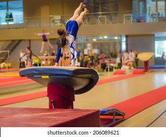 Young Gymnast Girl Performing Jump On A Vault While Practicing For The Competition