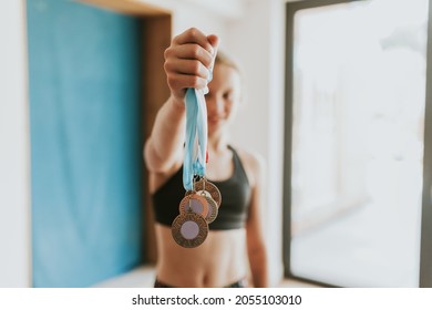 Young Gymnast Winner Holding Many Medals