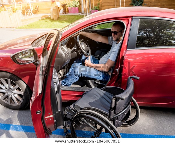 Young\
handicapped man on driver\'s seat of his\
car