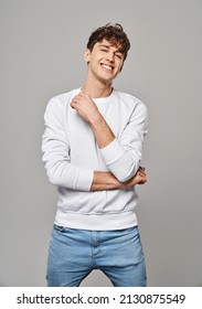 Young handome man smiling over gray background - Shutterstock ID 2130875549