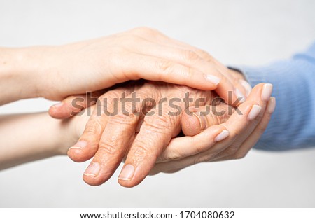 Young hands hold old hands. Support for the elderly concept. 