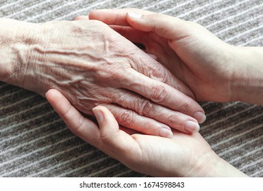 Junge Hände, die eine alte Frau halten, Nahaufnahme
