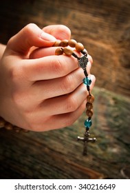 Young Hands With Wooden Rosary 