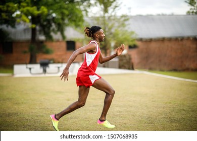 Young Handsome African American Black Male Outside Running In The Field Of A Small Town In Georgia City Ampitheater. Track And Field Star