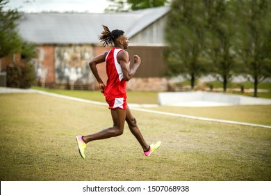 Young Handsome African American Black Male Outside Running In The Field Of A Small Town In Georgia City Ampitheater. Track And Field Star