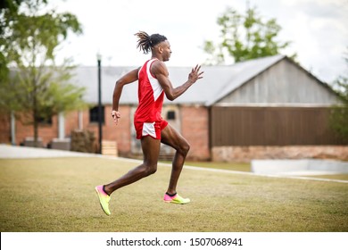 Young Handsome African American Black Male Outside Running In The Field Of A Small Town In Georgia City Ampitheater. Track And Field Star