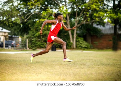 Young Handsome African American Black Male Outside Running In The Field Of A Small Town In Georgia City Ampitheater. Track And Field Star