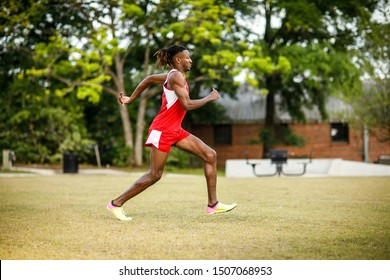 Young Handsome African American Black Male Outside Running In The Field Of A Small Town In Georgia City Ampitheater. Track And Field Star