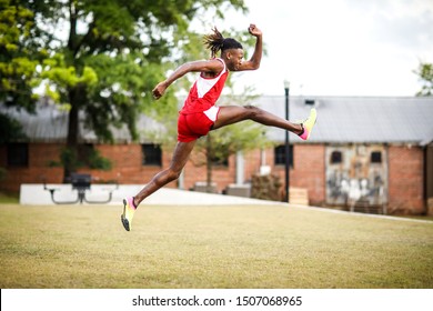 Young Handsome African American Black Male Outside Running In The Field Of A Small Town In Georgia City Ampitheater. Track And Field Star