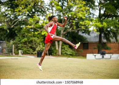 Young Handsome African American Black Male Outside Running In The Field Of A Small Town In Georgia City Ampitheater. Track And Field Star