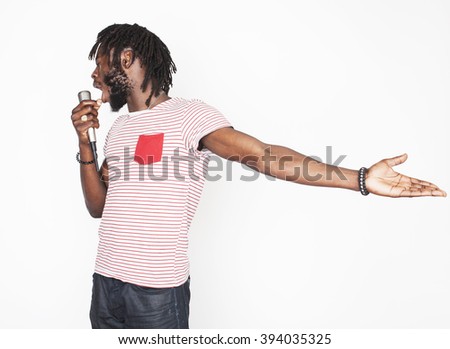 young handsome african american boy singing emotional with microphone isolated on white background, in motion gesturing