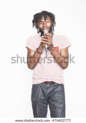 young handsome african american boy singing emotional with microphone isolated on white background, in motion gesturing smiling