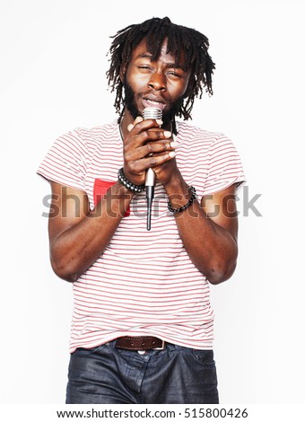 young handsome african american boy singing emotional with microphone isolated on white background, in motion gesturing smiling