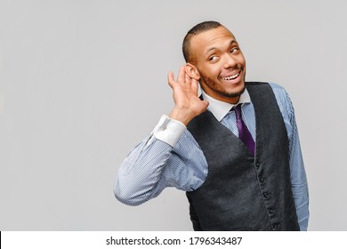 Junge, gut aussehende afroamerikanische Geschäftsleute, die etwas hören oder abhören, können Ihr Konzept auf grauem Hintergrund nicht hören