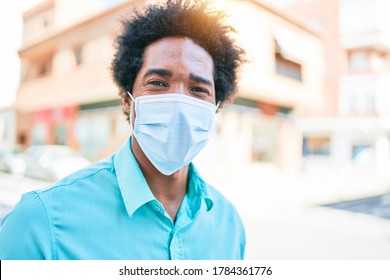 Young handsome african american man wearing casual clothes and medical mask smiling happy walking at town street. - Powered by Shutterstock