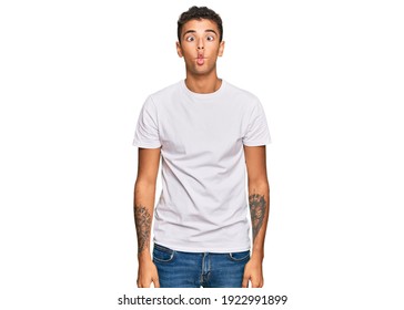 Young Handsome African American Man Wearing Casual White Tshirt Making Fish Face With Lips, Crazy And Comical Gesture. Funny Expression. 