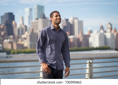 Young Handsome African American Man Smiling And Looking Optimistic With NYC Skyline In The Background