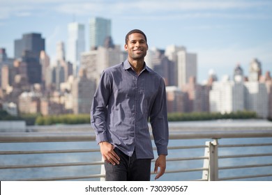 Young Handsome African American Man Smiling And Looking Optimistic, With NYC Skyline In The Background, Shot In NYC In September 2017