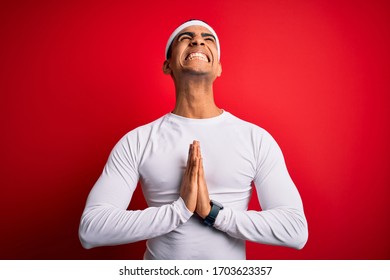 Young Handsome African American Sportsman Wearing Sportswear Over Red Background Begging And Praying With Hands Together With Hope Expression On Face Very Emotional And Worried. Begging.