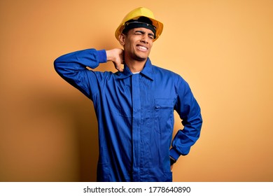 Young Handsome African American Worker Man Wearing Blue Uniform And Security Helmet Suffering Of Neck Ache Injury, Touching Neck With Hand, Muscular Pain