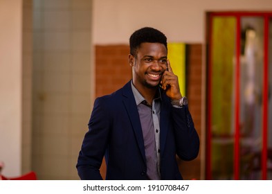 a young handsome african businessman feeling excited with the call he is receiving - Shutterstock ID 1910708467