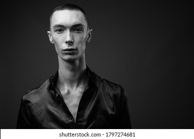 Young handsome androgynous businessman against gray background - Powered by Shutterstock