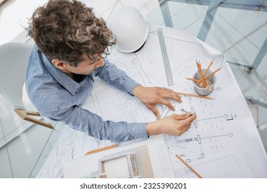 Young handsome architect engineer working on design plan