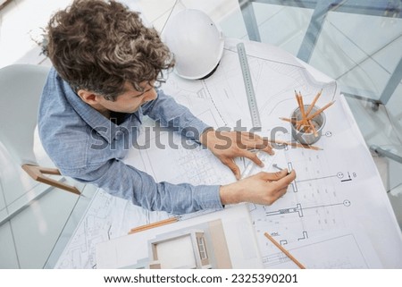 Young handsome architect engineer working on design plan