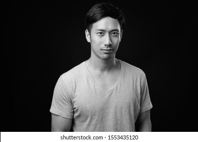 Young Handsome Asian Man Against Black Background