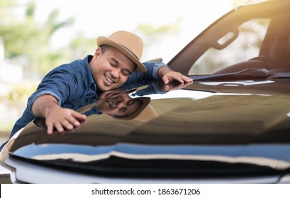Young handsome asian man getting the new car. He hugged his car and was very happy. Buy or rent car concept.