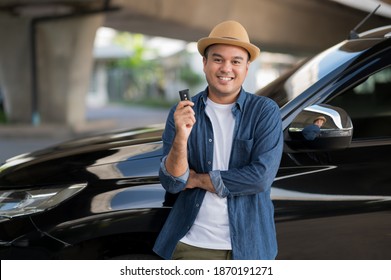 Young Handsome Asian Man Getting The New Car.He Showing Car Key And Very Happy. Buy Or Rent A Car Concept.