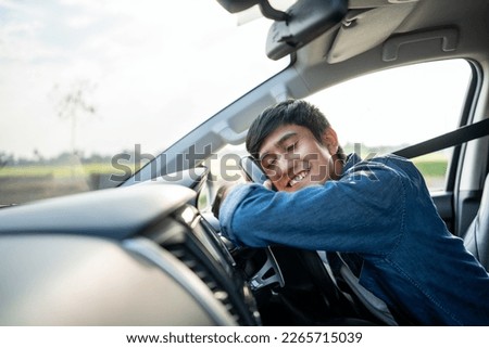 Young handsome asian man getting the new car. He hugged his car and was very happy touching detail interior . Buy or rent car concept. Foto d'archivio © 