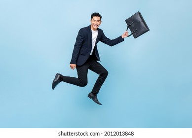 Young Handsome Asian Man Office Worker Holding Bag And Jumping In Light Blue Isolated Studio Background