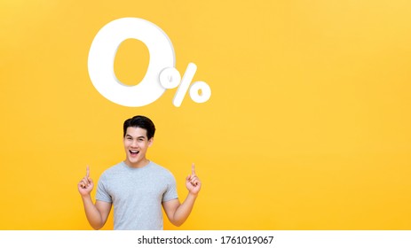 Young handsome Asian man pointing up to 0% on yellow background with copy space for no interest installment payment concept