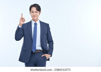 A young and handsome Asian man in a suit is wearing glasses and making various facial expressions and hand gestures.